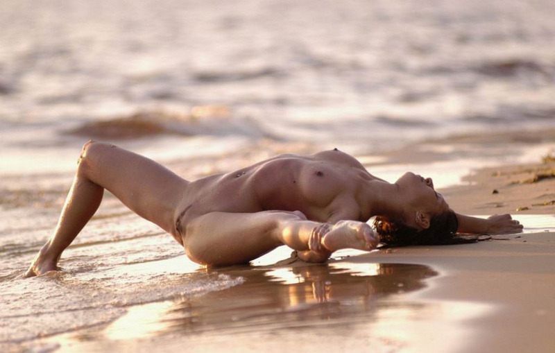 Голая гимнастка демонстрирует пластичность на морском пляже 8 фото