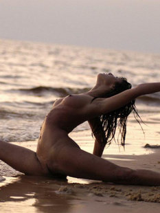 Голая гимнастка демонстрирует пластичность на морском пляже