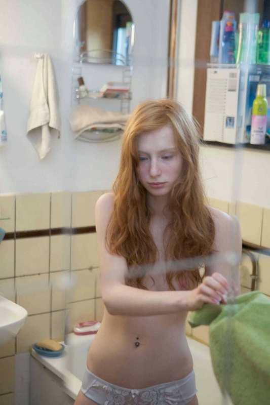 Худая девушка с рыжими волосами намыливает тело в ванной 1 фото