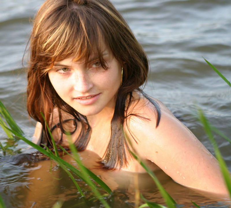 Милая молодая девушка позирует на берегу реки 5 фото