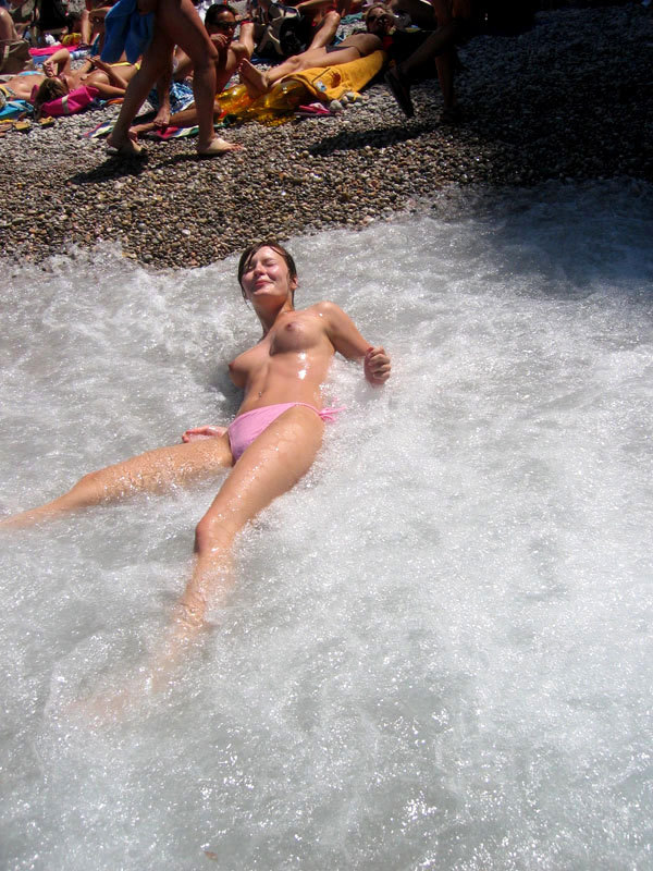 Славянка на курорте загорает топлес и купается голышом на пляже 9 фото