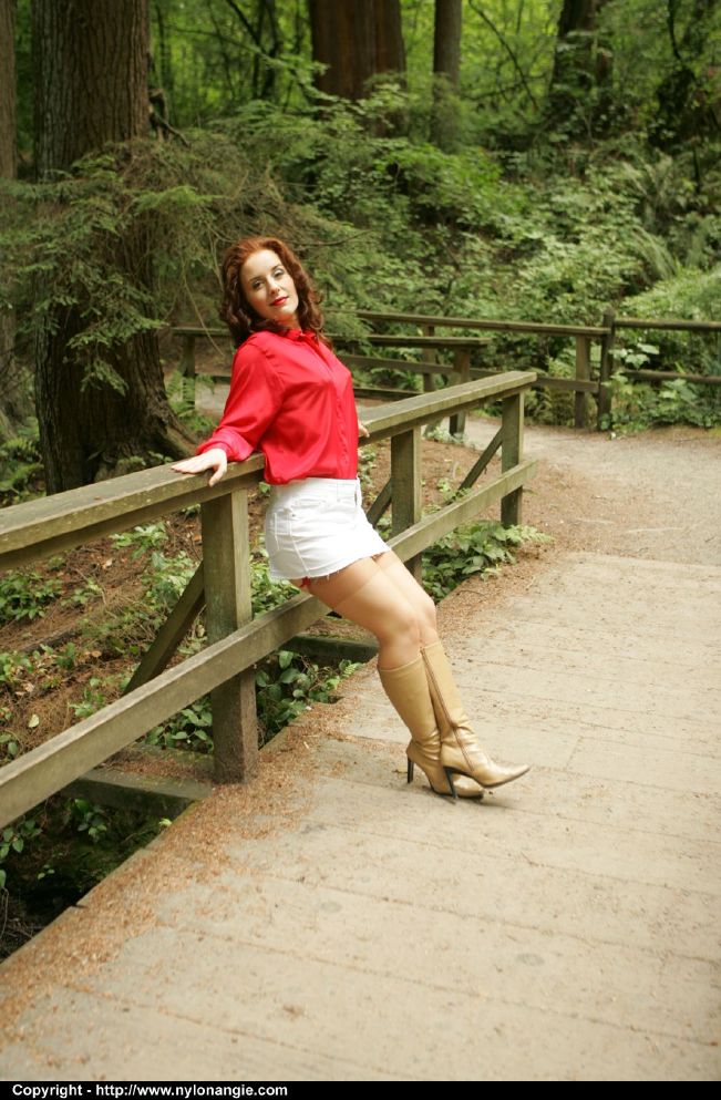 Рыжая зрелка в сапогах и чулках задирает белую юбку в парке 2 фото
